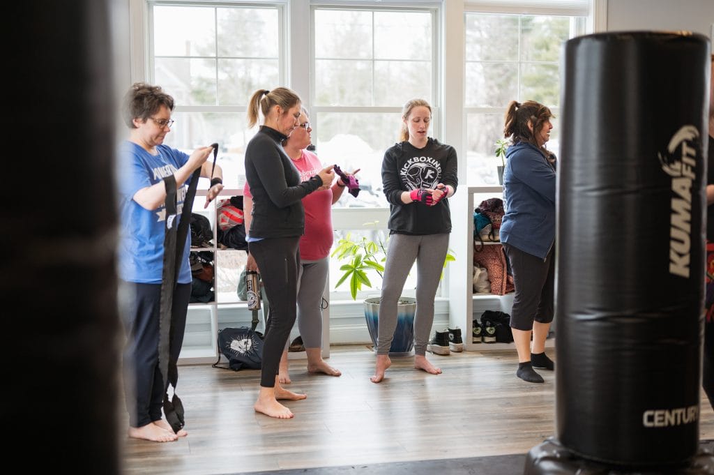 A group of people fostering a welcoming space for women in a gym.