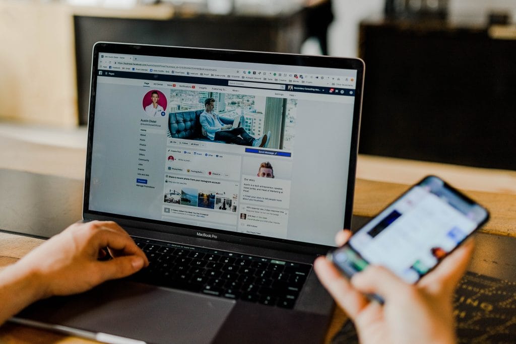 A fitness enthusiast is using a laptop with a Facebook page on it.